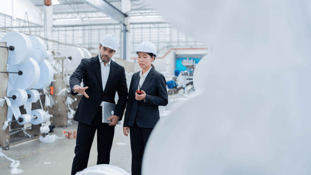 Two professionals in hard hats discussing contractor lead generation companies strategies in industrial facility