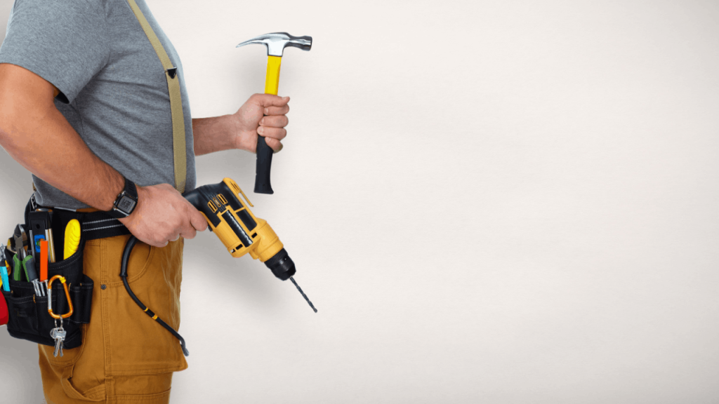 Handyman leads professional holding drill and hammer with tool belt ready for jobs